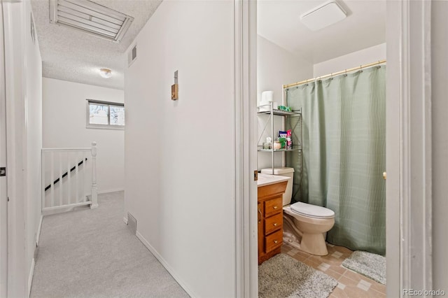 bathroom with vanity, a textured ceiling, and toilet