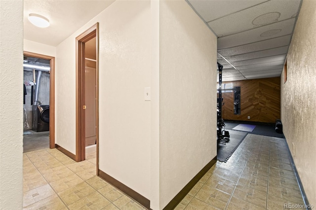 corridor with a paneled ceiling