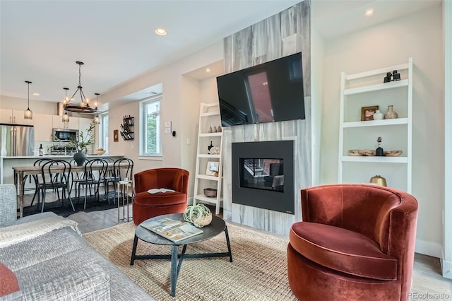 1895 York St, Denver, CO 80206 - living area with a large fireplace, light wood finished floors, recessed lighting, built in shelves, and a chandelier