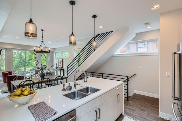 1895 York St, Denver, CO 80206 - kitchen featuring light countertops, recessed lighting, wood finished floors, hanging light fixtures, and white cabinetry