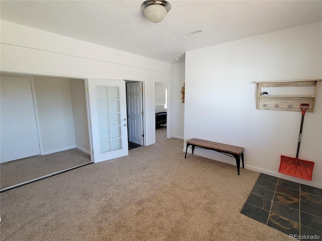 unfurnished bedroom with carpet floors, visible vents, and baseboards