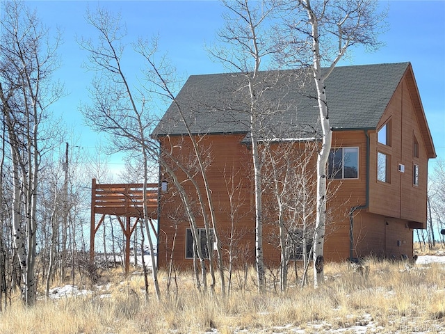 view of side of property featuring a shingled roof