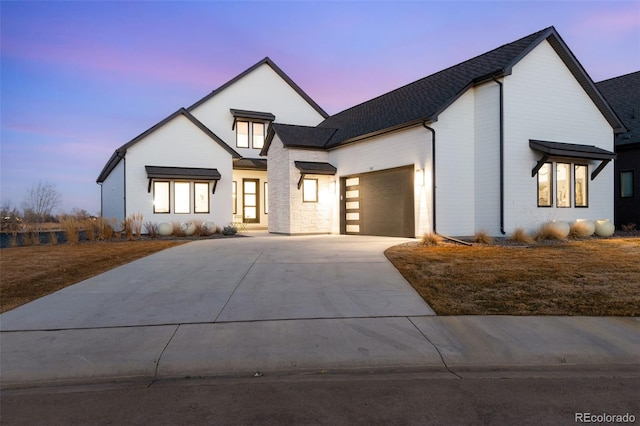 modern inspired farmhouse with an attached garage and concrete driveway