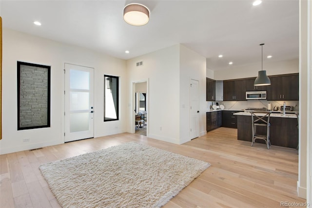 foyer entrance with recessed lighting, baseboards, and light wood-style flooring