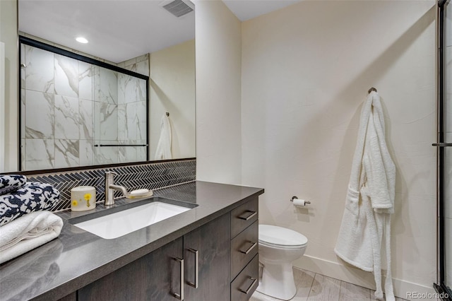 full bathroom featuring vanity, visible vents, a stall shower, toilet, and tasteful backsplash