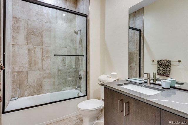 bathroom featuring vanity, toilet, and shower / bath combination with glass door