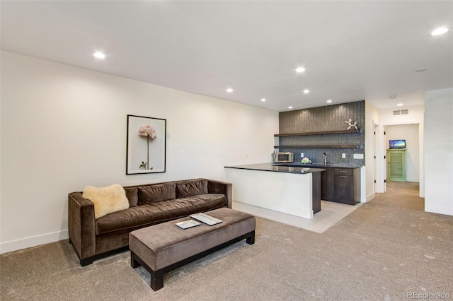 living area with visible vents, baseboards, wet bar, recessed lighting, and light colored carpet