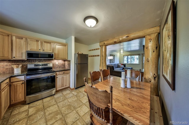 446 Hi Country Drive 17 & 18, Winter Park, CO 80482 - kitchen featuring appliances with stainless steel finishes, tasteful backsplash, light stone finish flooring, dark stone counters, and light brown cabinetry