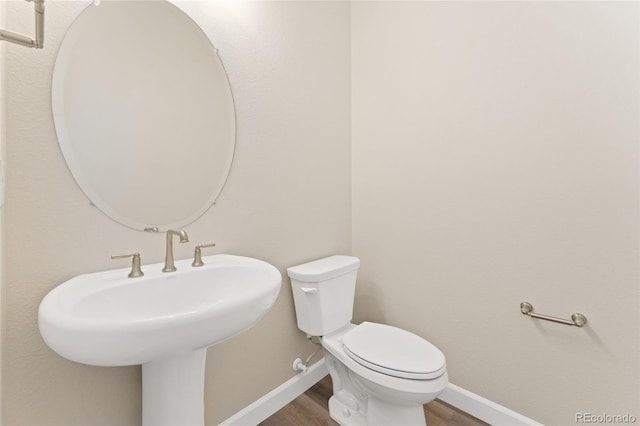 7051 S White Crow Way, Aurora, CO 80016 - half bath with baseboards, wood finished floors, and toilet