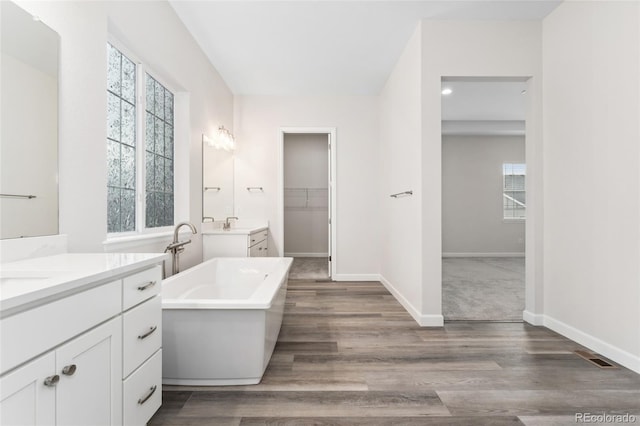 7051 S White Crow Way, Aurora, CO 80016 - full bath with wood finished floors, plenty of natural light, and a freestanding bath