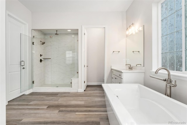7051 S White Crow Way, Aurora, CO 80016 - full bath with a stall shower, wood finished floors, a freestanding bath, and vanity