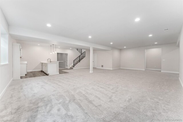 7051 S White Crow Way, Aurora, CO 80016 - finished basement featuring light carpet, recessed lighting, stairway, a sink, and baseboards