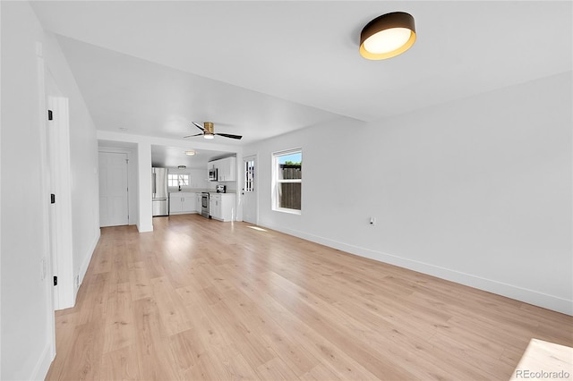 3064 S Galapago St, Englewood, CO 80110 - unfurnished living room with light wood-type flooring, baseboards, and a ceiling fan