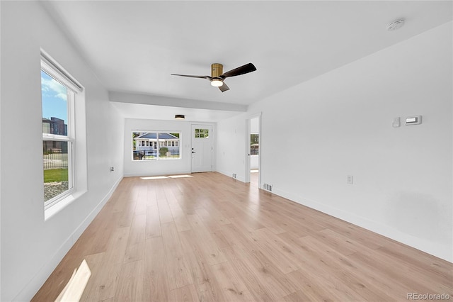 3064 S Galapago St, Englewood, CO 80110 - unfurnished living room featuring plenty of natural light, light wood-style floors, a ceiling fan, and baseboards
