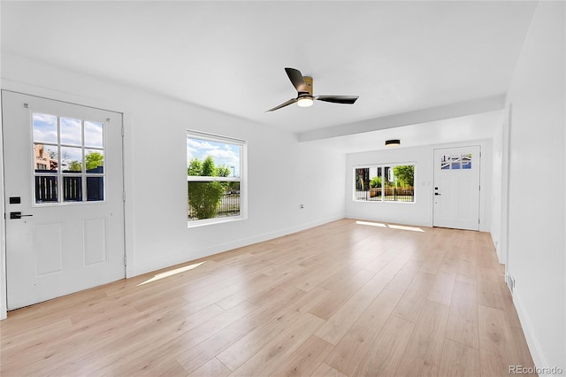 3064 S Galapago St, Englewood, CO 80110 - unfurnished living room featuring healthy amount of natural light, light wood-style floors, and baseboards