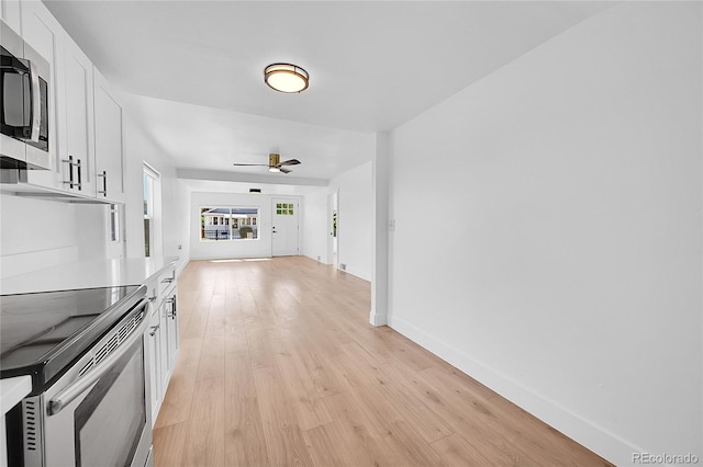 3064 S Galapago St, Englewood, CO 80110 - unfurnished living room featuring light wood-style floors, a ceiling fan, and baseboards