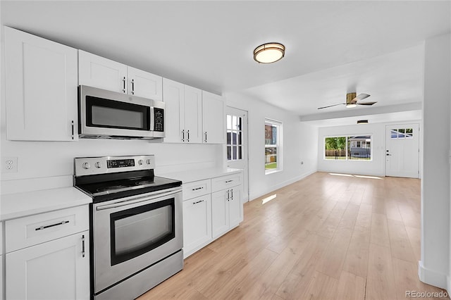 3064 S Galapago St, Englewood, CO 80110 - kitchen with appliances with stainless steel finishes, light countertops, white cabinetry, and open floor plan