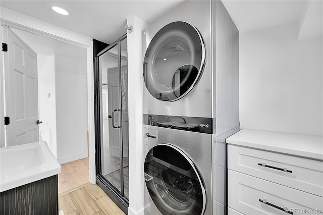 3064 S Galapago St, Englewood, CO 80110 - laundry room featuring stacked washer / drying machine, recessed lighting, and light wood-style flooring