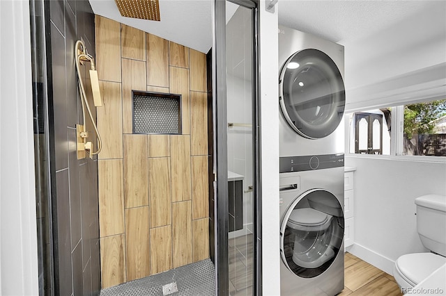 3064 S Galapago St, Englewood, CO 80110 - laundry area with stacked washer / drying machine, light wood-style flooring, a textured ceiling, and baseboards