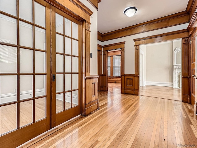 1453 Vine St, Denver, CO 80206 - spare room with light wood finished floors, crown molding, a wainscoted wall, and a decorative wall