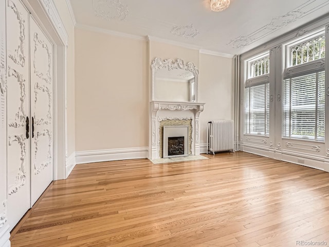 1453 Vine St, Denver, CO 80206 - unfurnished living room featuring radiator heating unit, hardwood / wood-style flooring, ornamental molding, french doors, and a fireplace with flush hearth