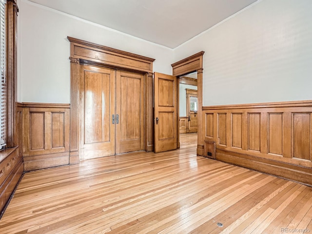 1453 Vine St, Denver, CO 80206 - unfurnished bedroom with a wainscoted wall, light wood-style floors, and ornamental molding
