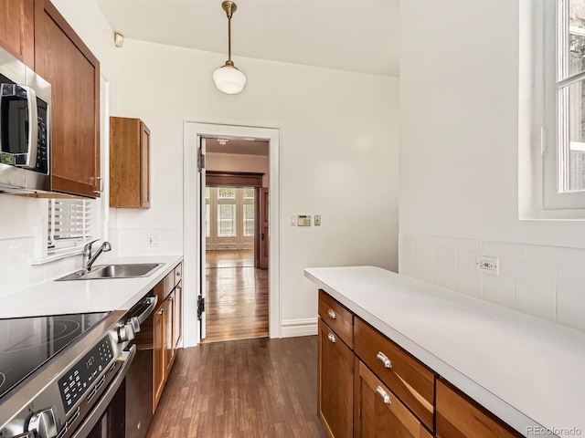 1453 Vine St, Denver, CO 80206 - kitchen featuring a sink, appliances with stainless steel finishes, dark wood-style flooring, brown cabinetry, and light countertops