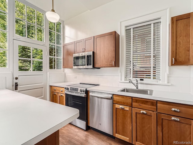 1453 Vine St, Denver, CO 80206 - kitchen with appliances with stainless steel finishes, a sink, light countertops, backsplash, and pendant lighting
