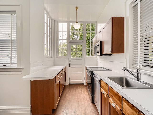 1453 Vine St, Denver, CO 80206 - kitchen featuring a sink, appliances with stainless steel finishes, plenty of natural light, and brown cabinets