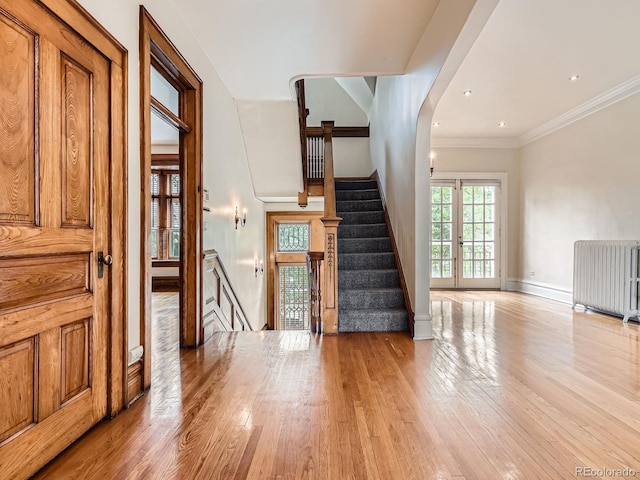 1453 Vine St, Denver, CO 80206 - stairs with radiator heating unit, wood finished floors, baseboards, and ornamental molding
