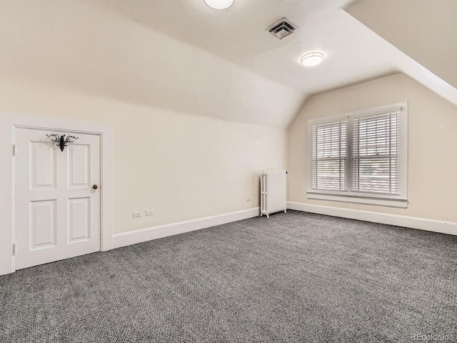 1453 Vine St, Denver, CO 80206 - additional living space featuring radiator heating unit, vaulted ceiling, dark colored carpet, and baseboards
