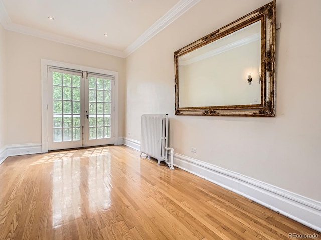 1453 Vine St, Denver, CO 80206 - spare room with radiator, ornamental molding, wood finished floors, french doors, and baseboards