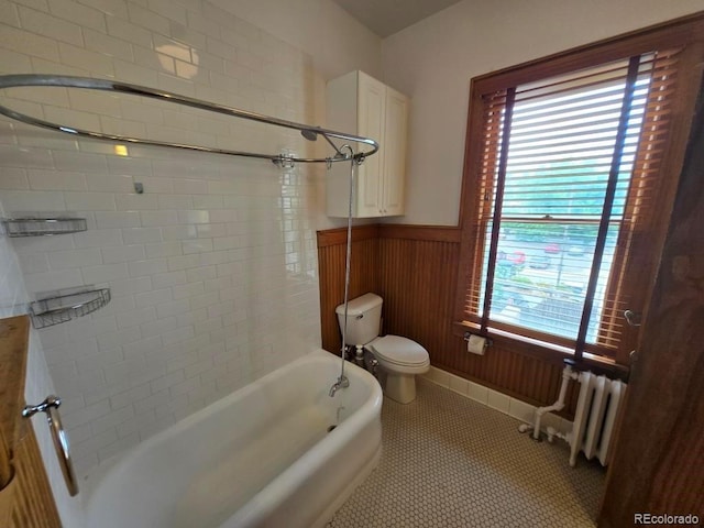 1453 Vine St, Denver, CO 80206 - bathroom featuring radiator heating unit, a wainscoted wall, tile patterned flooring, and bathtub / shower combination