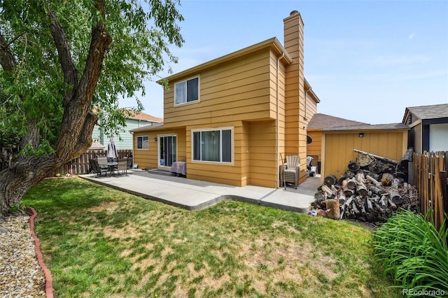 20651 E 42nd Ave, Denver, CO 80249 - back of property with a chimney, a patio area, and a fenced backyard
