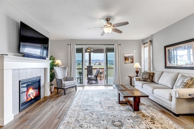 9055 Swan River St, Littleton, CO 80125 - living area with ceiling fan, wood finished floors, and a fireplace
