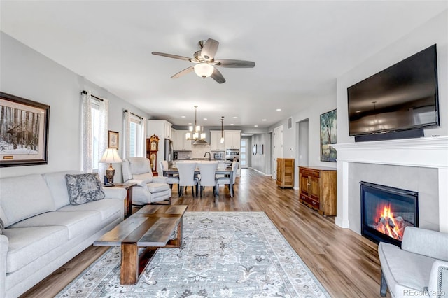 9055 Swan River St, Littleton, CO 80125 - living area with ceiling fan, light wood finished floors, a glass covered fireplace, and recessed lighting