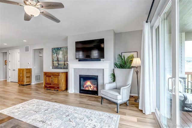 9055 Swan River St, Littleton, CO 80125 - living area featuring light wood finished floors, a fireplace, a ceiling fan, and recessed lighting