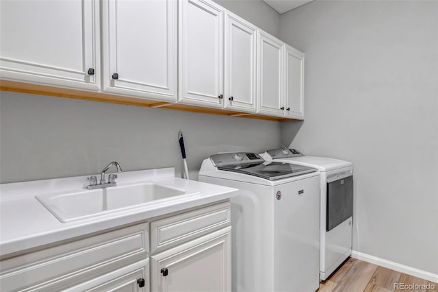 9055 Swan River St, Littleton, CO 80125 - laundry area with cabinet space, separate washer and dryer, and light wood-style flooring