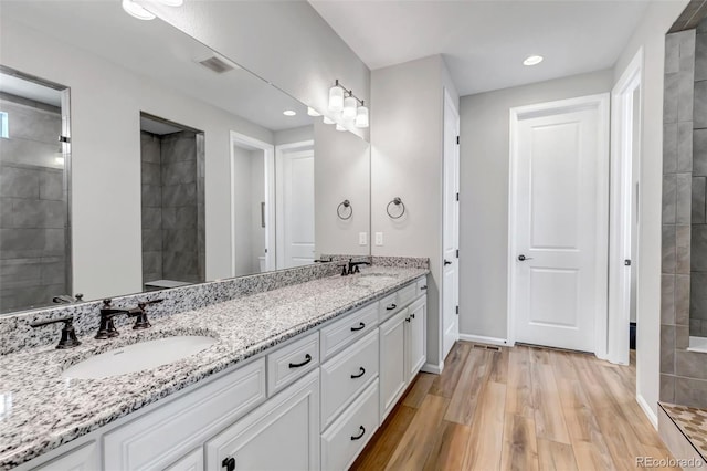 9055 Swan River St, Littleton, CO 80125 - full bath featuring double vanity, wood finished floors, and recessed lighting