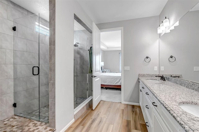 9055 Swan River St, Littleton, CO 80125 - ensuite bathroom with wood finished floors, double vanity, and a shower stall