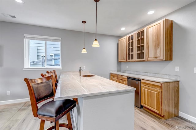 9055 Swan River St, Littleton, CO 80125 - kitchen with light wood-style flooring, a kitchen breakfast bar, glass insert cabinets, light countertops, and recessed lighting