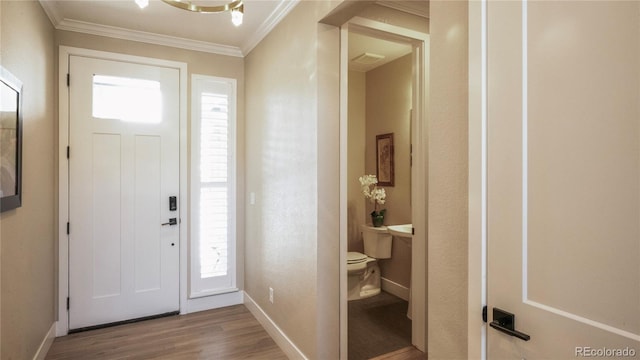 entrance foyer featuring crown molding and light hardwood / wood-style floors