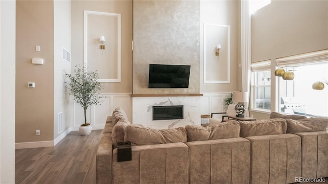 living room featuring dark hardwood / wood-style flooring and a premium fireplace