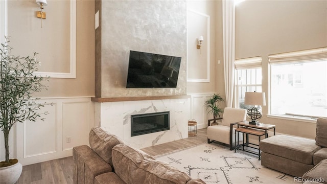 living room featuring a high end fireplace and light wood-type flooring