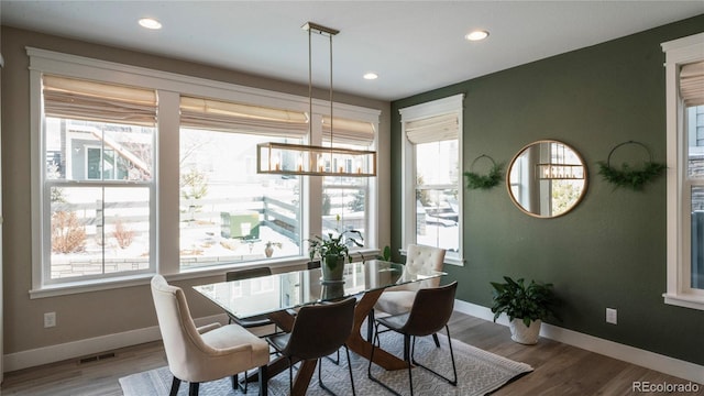 dining room with wood-type flooring and a chandelier