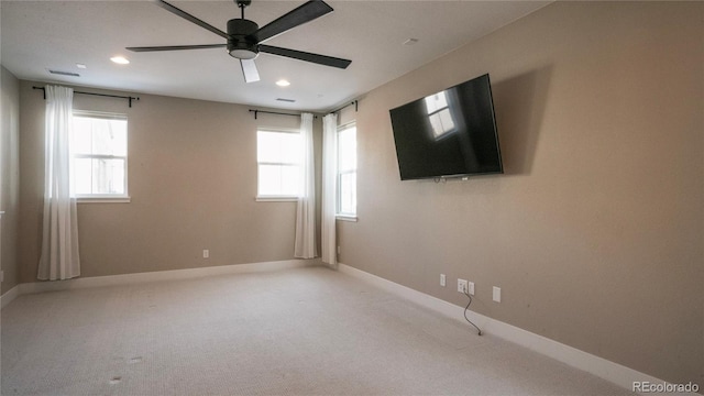 carpeted spare room featuring ceiling fan