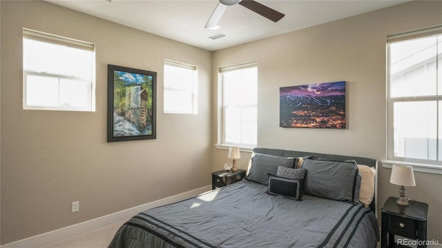 carpeted bedroom with multiple windows and ceiling fan