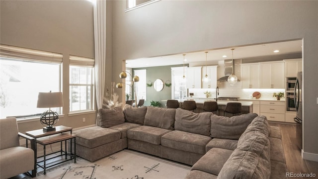 living room with light hardwood / wood-style flooring and a high ceiling