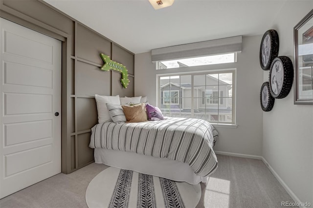 bedroom with light carpet and baseboards