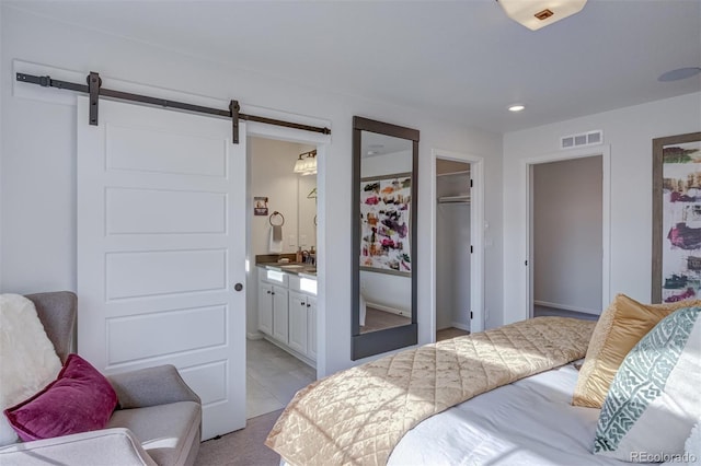 bedroom with recessed lighting, a closet, visible vents, a barn door, and connected bathroom